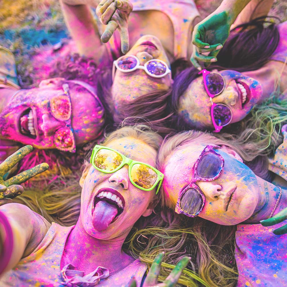 women in glasses laying down covered in paint