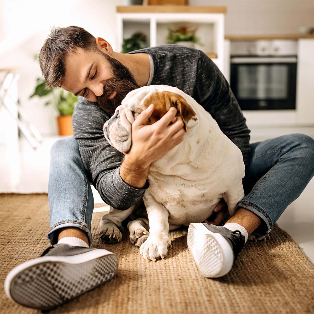 man cuddling a dog